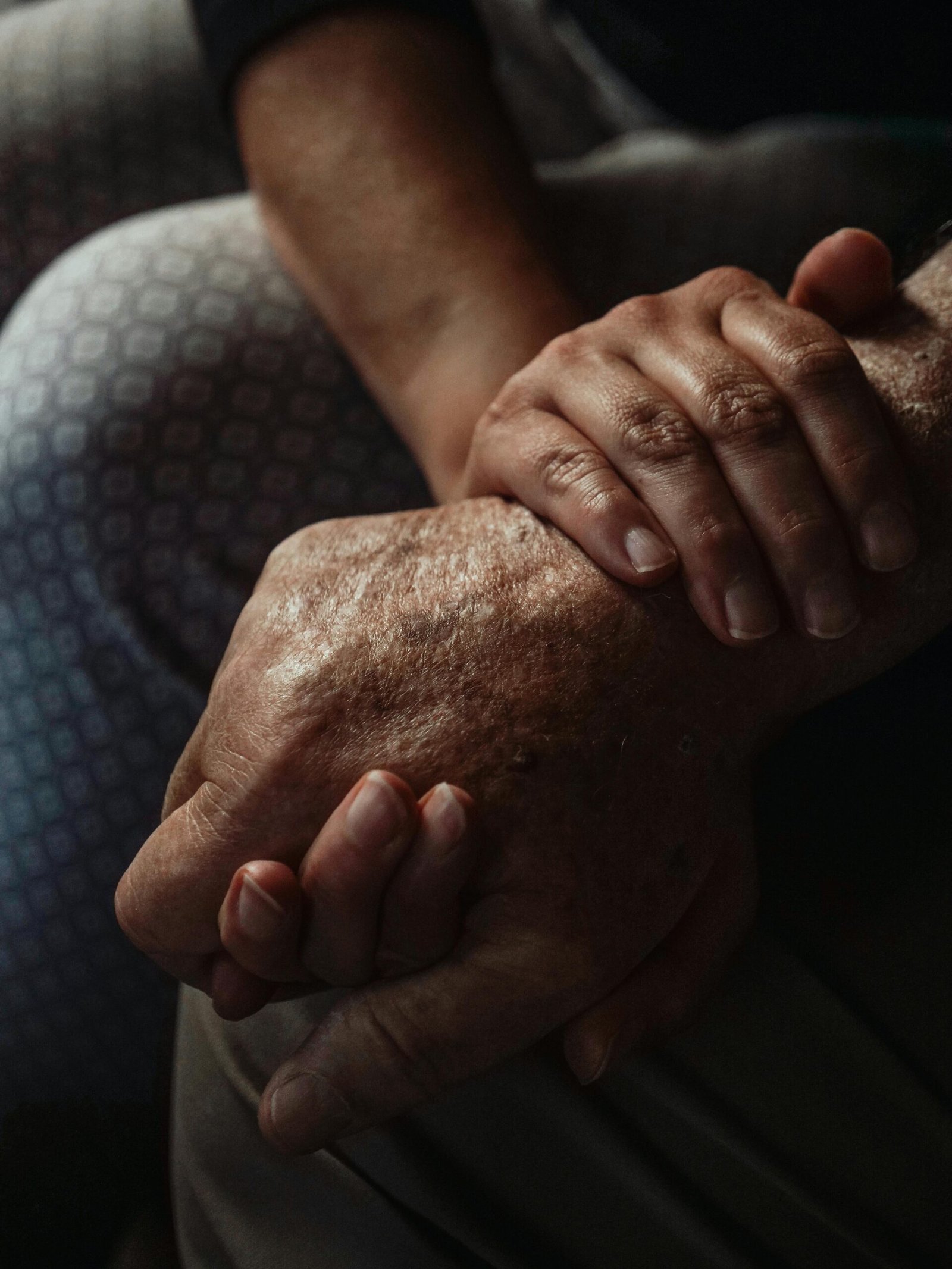 A touching close-up of hands symbolizing support and compassion between generations.